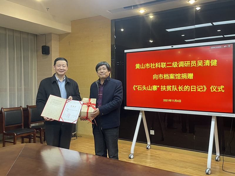 市社科联二级调研员吴清健向市档案馆捐赠《“石头山寨”扶贫队长的日记》一书